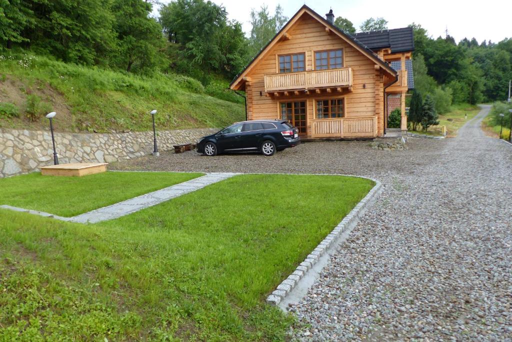 a car parked in front of a log cabin at Dom nad Popradem in Stary Sącz