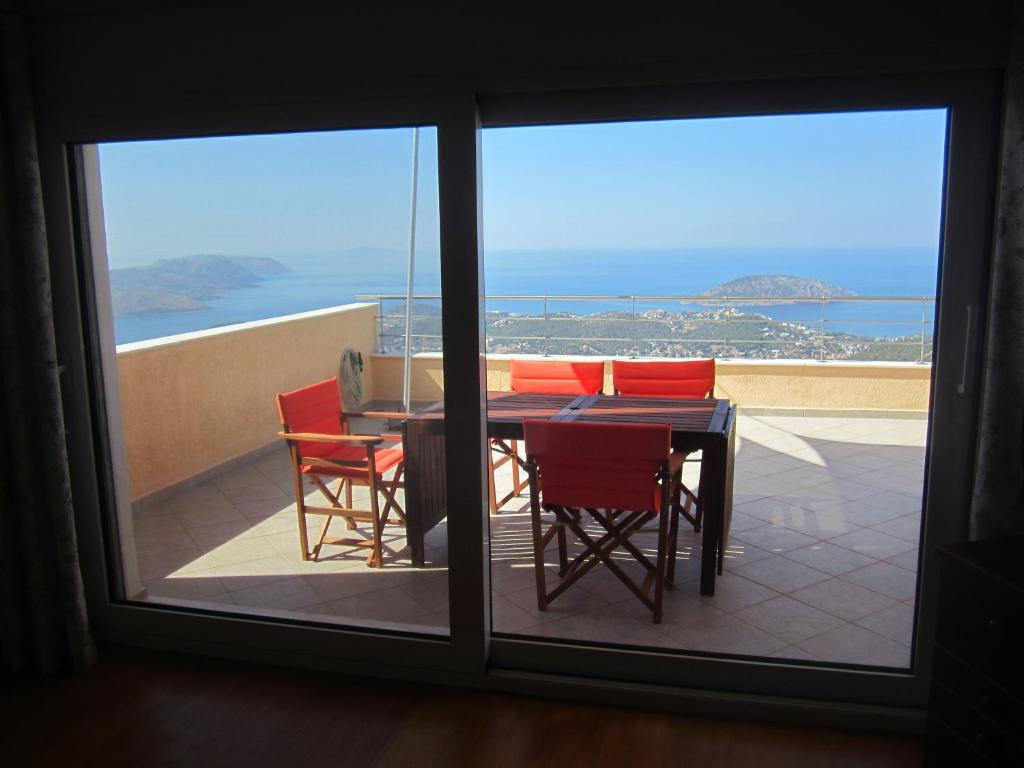 a table and chairs on a balcony with a view of the ocean at Viva B&B in Anavyssos