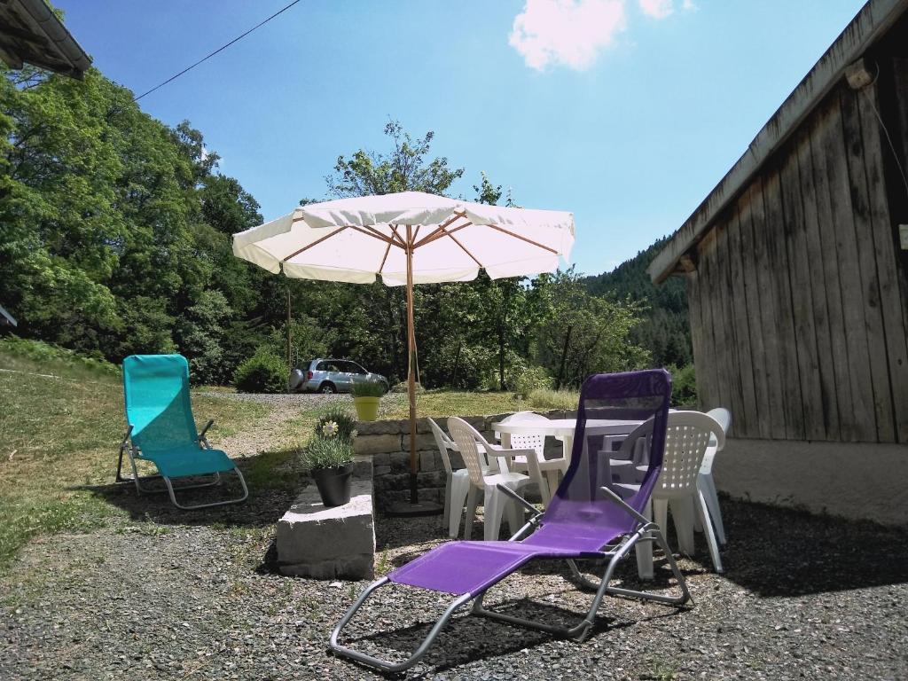 a group of lawn chairs and an umbrella at Gîte du Charri in Le Tholy