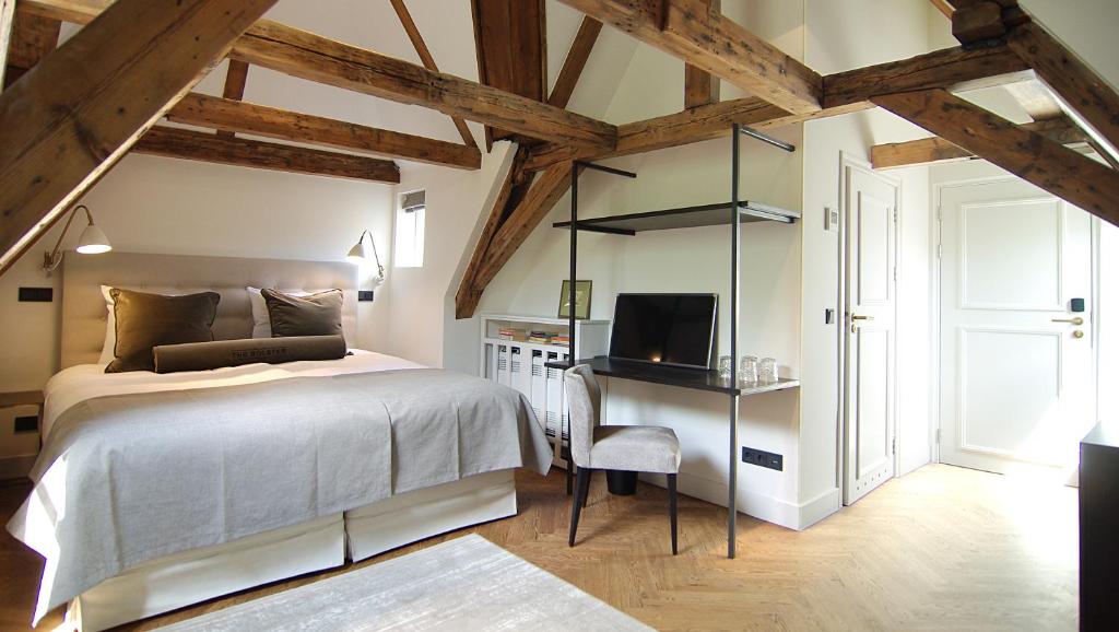 Un dormitorio con una cama y un escritorio con televisión. en The Bolster, en Ámsterdam