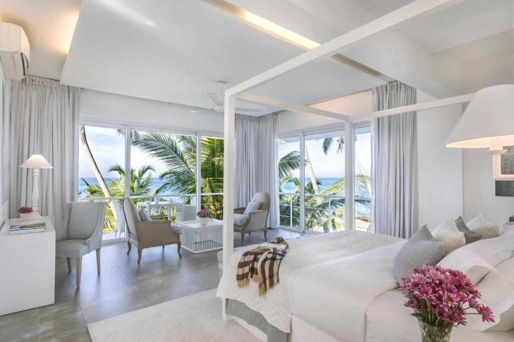 a bedroom with a large bed with a view of the ocean at The Sandals By Edwards Collection in Hikkaduwa