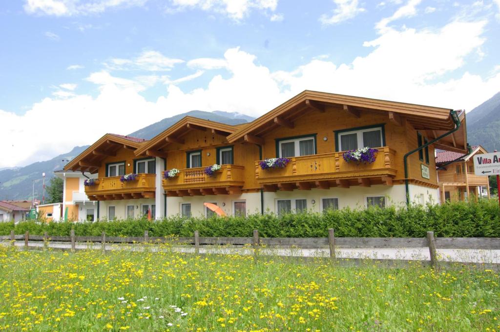 una casa en las montañas con un campo delante en Chalet Tirolerland, en Mayrhofen