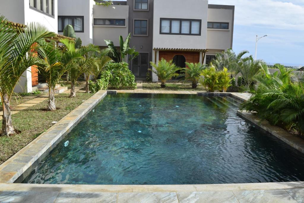 a swimming pool in the backyard of a house at Ocean Mist in Flic-en-Flac