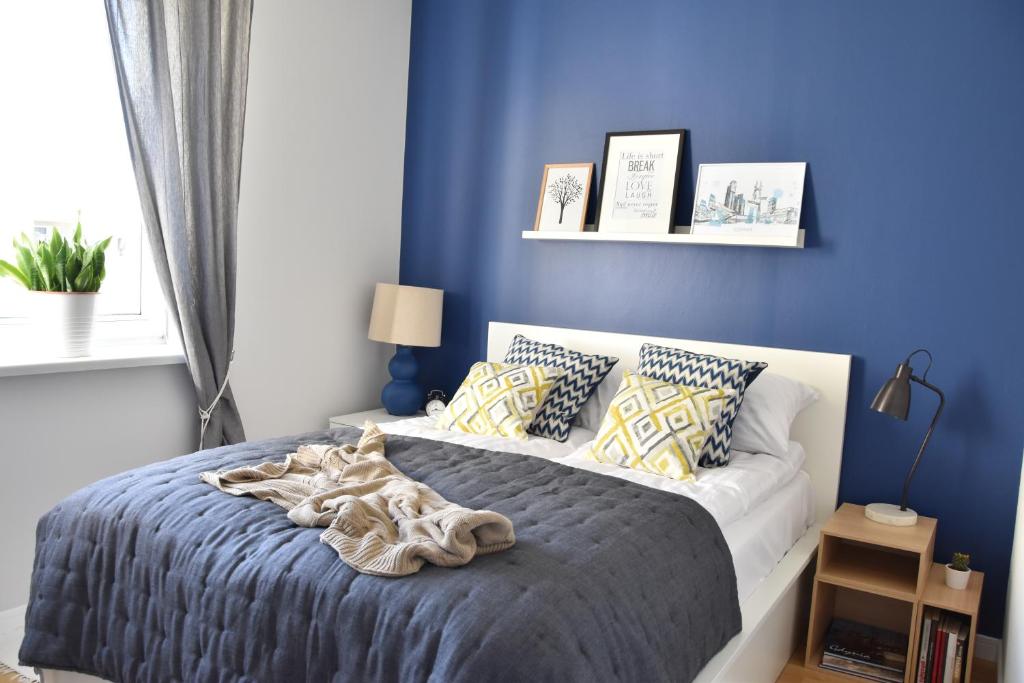 グディニャにあるGdynia4You Apartmentの青い壁のベッド付きの青いベッドルーム1室