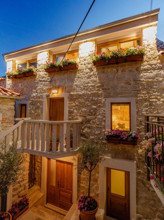 a stone house with flower boxes on the facade at Stone house luxury rooms in Split