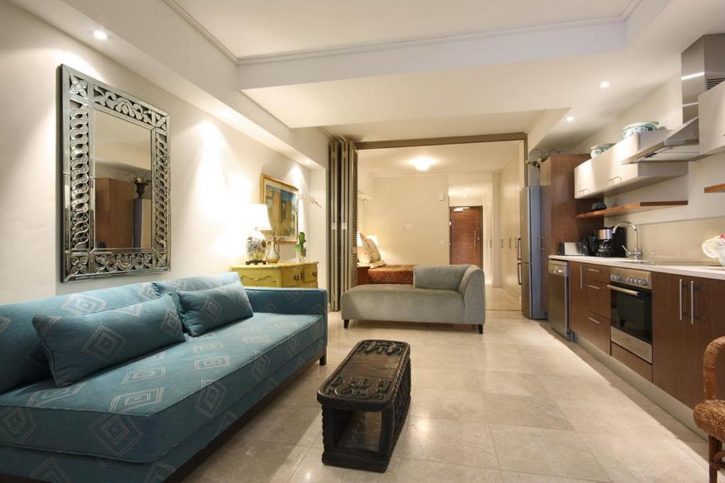 un soggiorno con divano blu e una cucina di 702 Canal Quays a Città del Capo