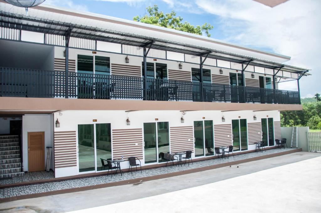 - une vue extérieure sur un bâtiment avec des tables et des chaises dans l'établissement Pleai Ta Lea Resort, à Chao Lao Beach