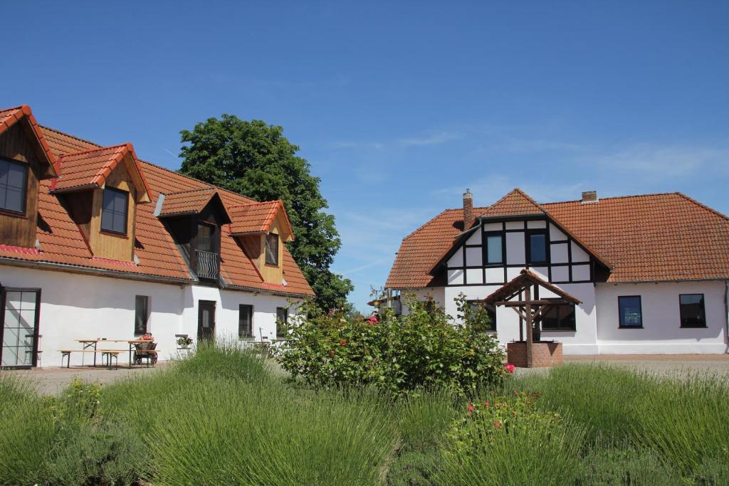 ein Haus mit einem gefliesten Dach neben einem anderen Gebäude in der Unterkunft Radler's Hof in Letschin