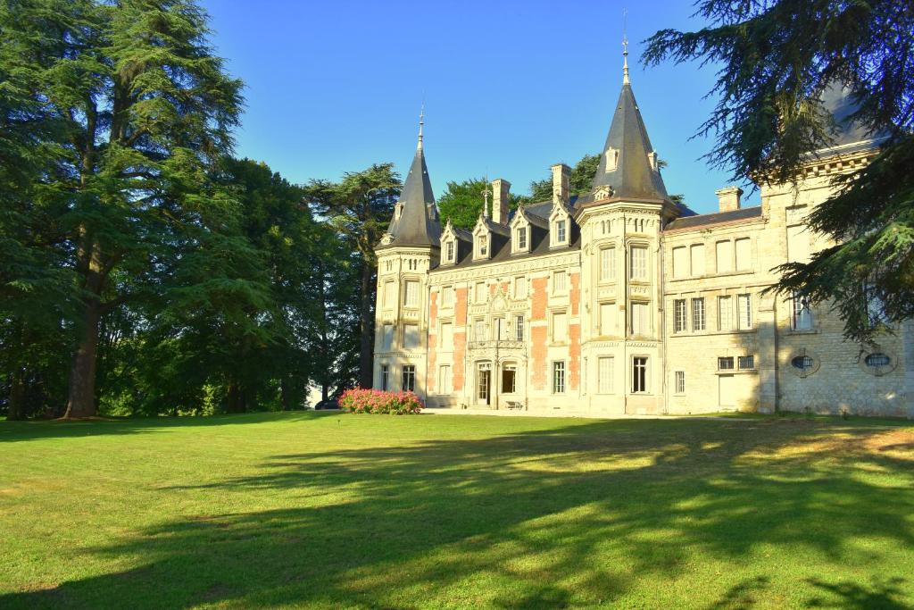 un antiguo castillo con un gran patio de césped en Chateau de Varambon, en Varambon