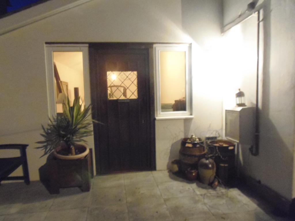 Zimmer mit Tür und Topfpflanze in der Unterkunft Dippy cottage in Bexhill