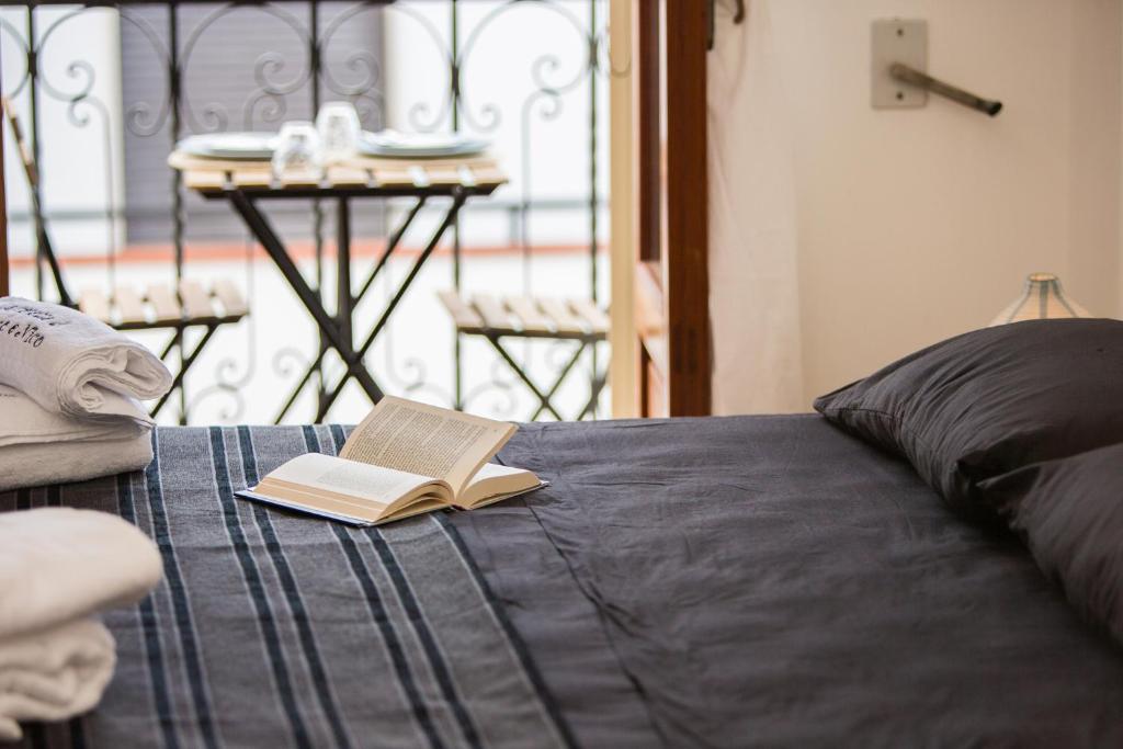 un libro seduto sopra un letto con un tavolo di Le Stanze Di Brando E Nico a Tricase