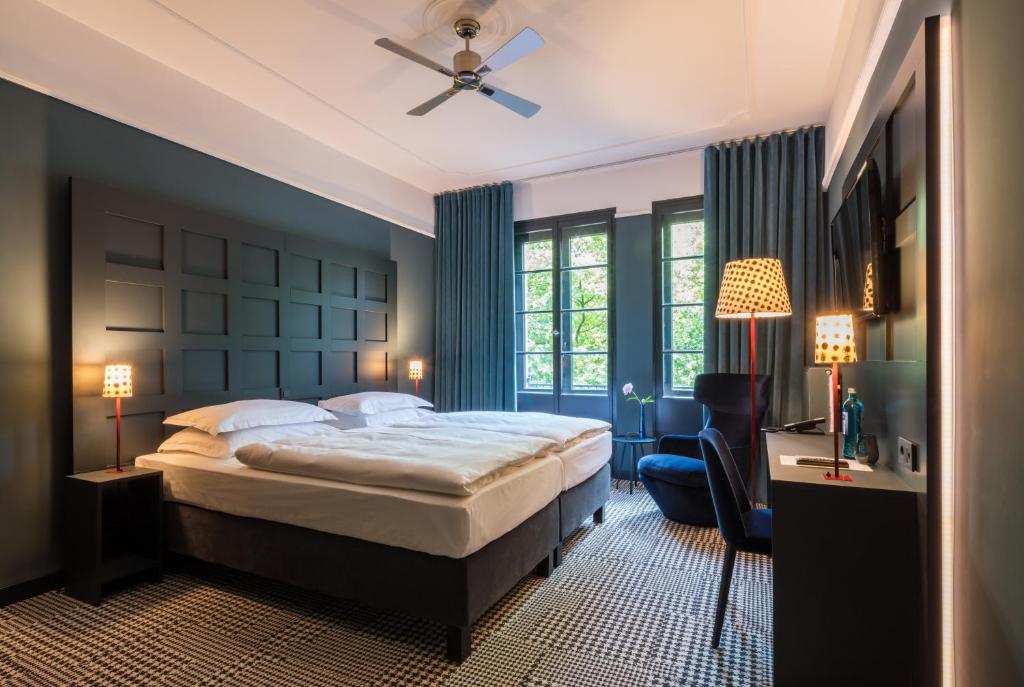 a bedroom with a bed and a desk and a chair at The Midtown Hotel in Cologne