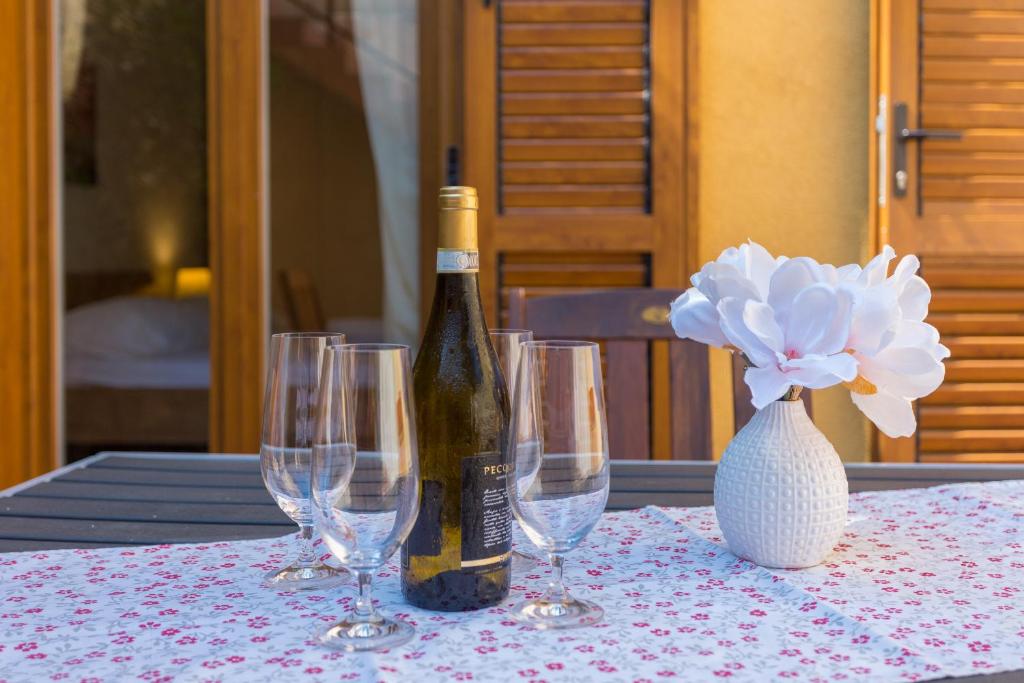 uma garrafa de vinho sentada numa mesa com copos de vinho em Villa Mimma Dubrovnik em Dubrovnik