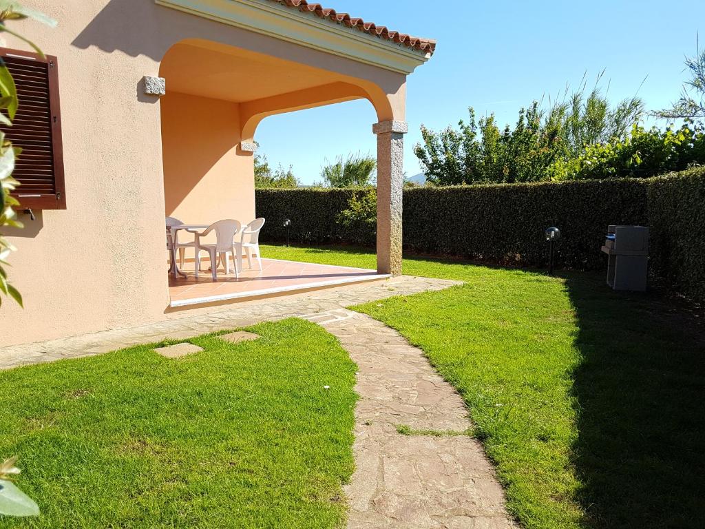 a patio with a table and chairs in a yard at Appartamenti Airone in San Teodoro