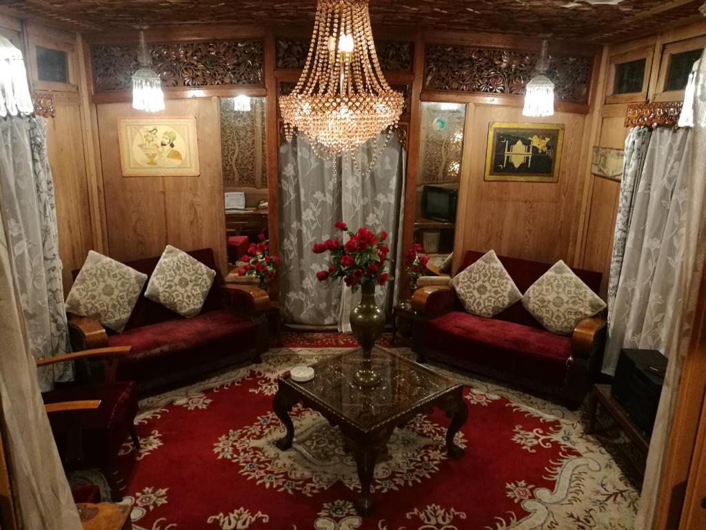 a living room with red couches and a chandelier at House Boat Hardy Palace in Srinagar