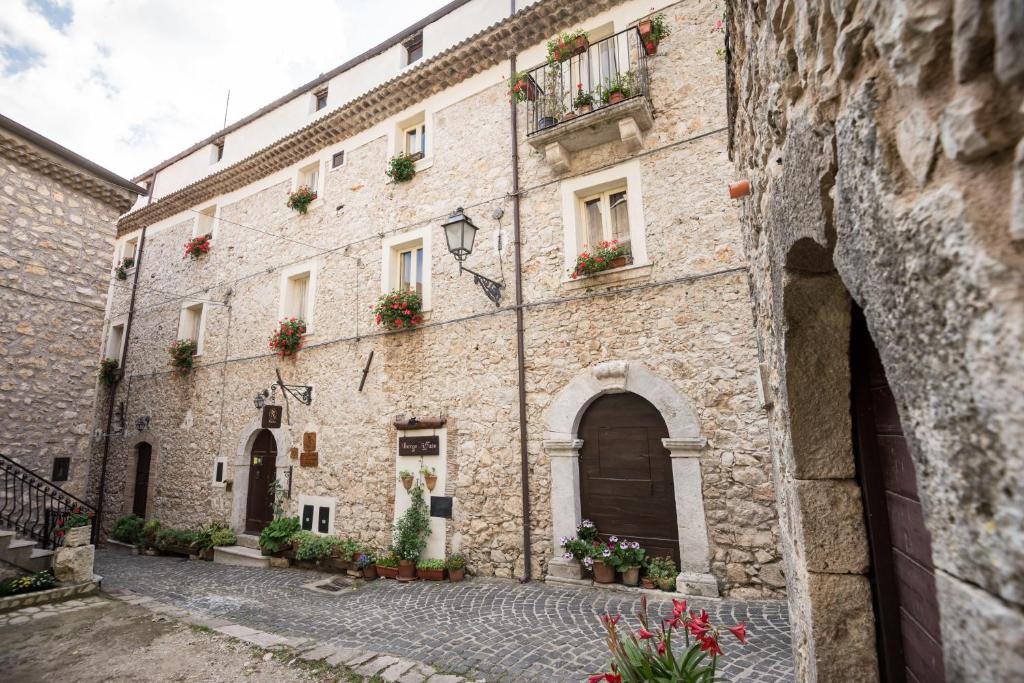 stary kamienny budynek z skrzyniami kwiatowymi w obiekcie Nenà Al Borgo Castello w mieście Pico