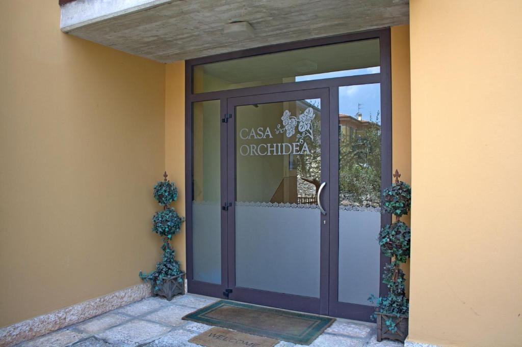 a door to a building with a sign on it at Casa Orchidea Apartments in Torri del Benaco