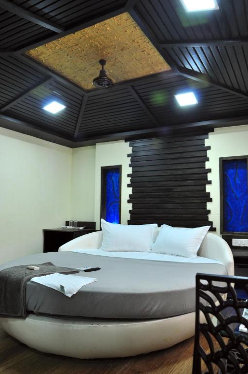 Postel nebo postele na pokoji v ubytování Hotel Anandhiram Heritage