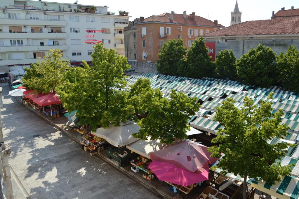 une vue sur un marché extérieur avec des parasols dans l'établissement Apartments Silvia, à Zadar