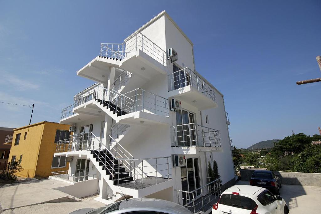 een wit gebouw met trappen aan de zijkant bij Apartments Victoria in Sutomore