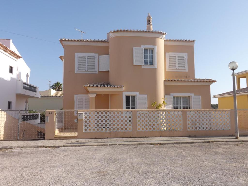 una casa con una valla delante de ella en Vila apartamentos Estrela, en Lagos