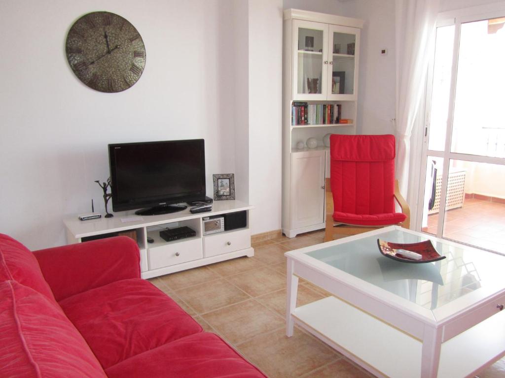 ネルハにあるCarabeo 2000 3.1のリビングルーム(赤いソファ、テレビ付)