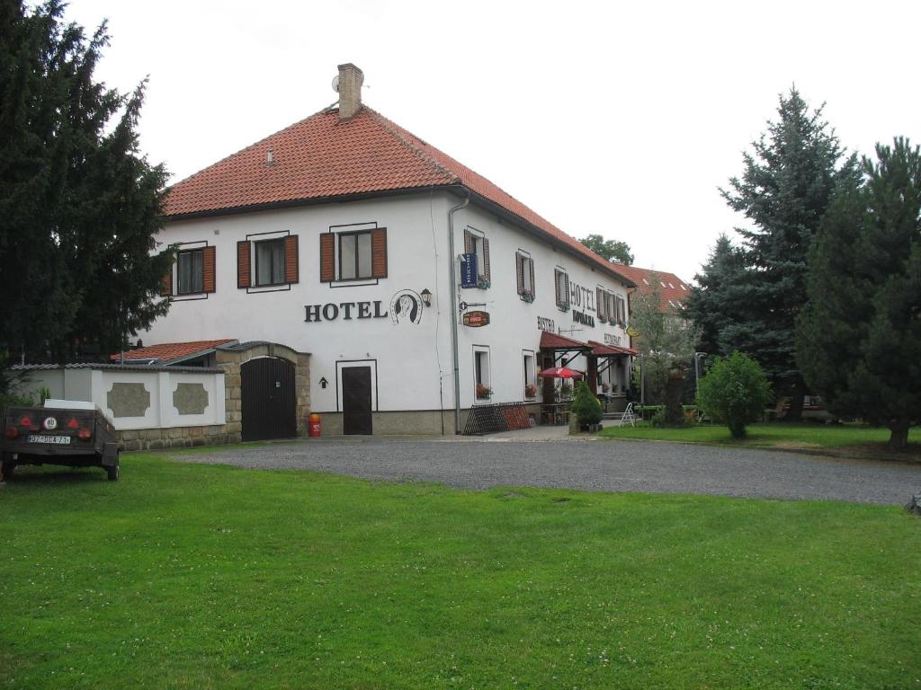 a hotel building with a green lawn in front of it at Hotel Kovarna in Děčín