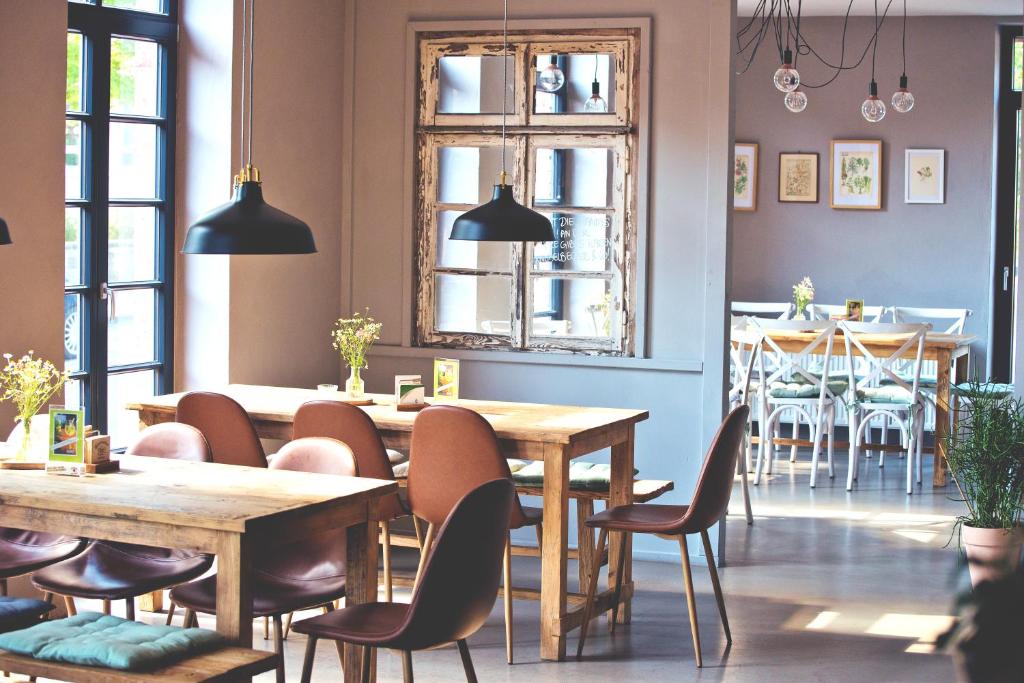 un restaurant avec des tables et des chaises en bois et une salle à manger dans l'établissement Alte Heimat, à Berge
