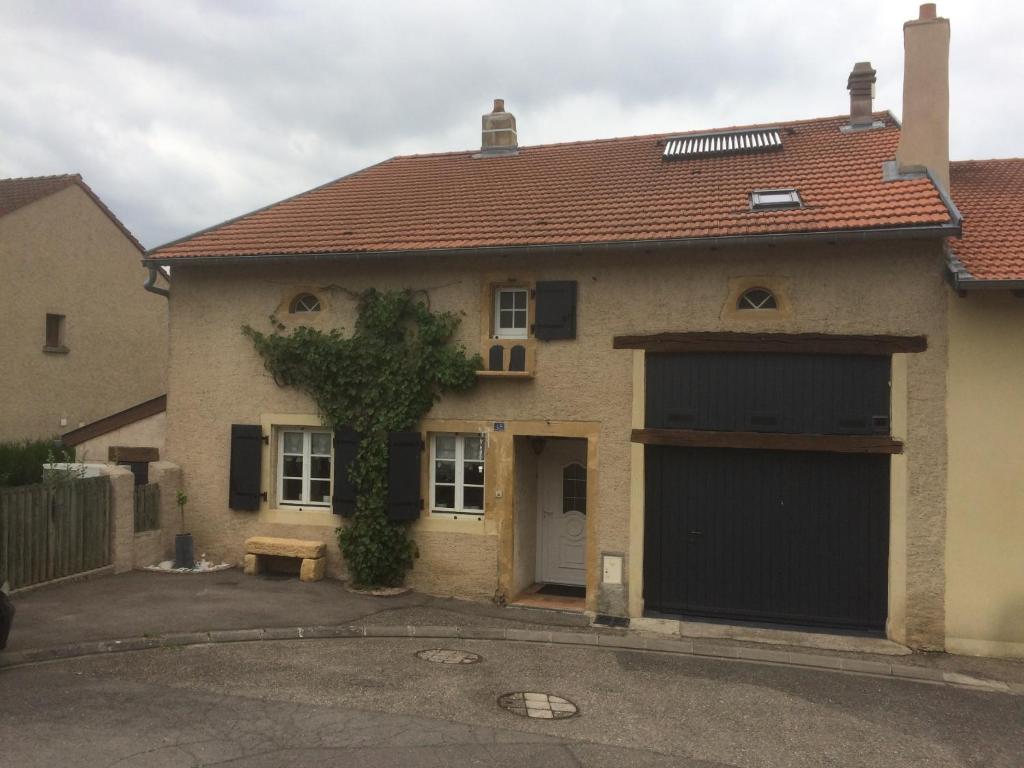 a house with a large garage with a car at Le coup de coeur in Coincy