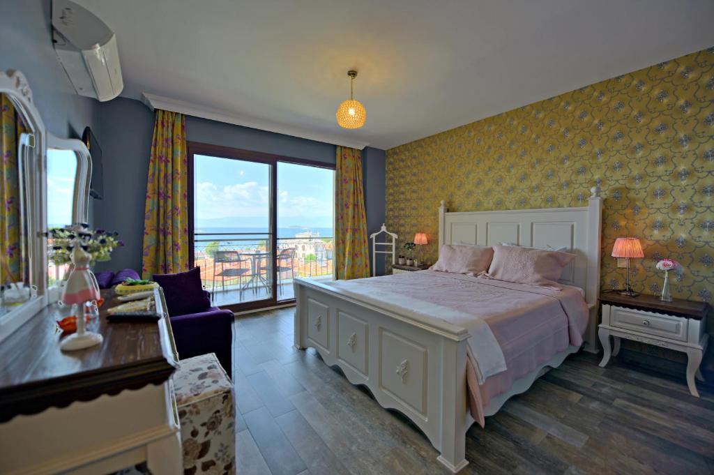 アイワルクにあるNilüfer Butik Otelのベッドルーム(大型ベッド1台、大きな窓付)