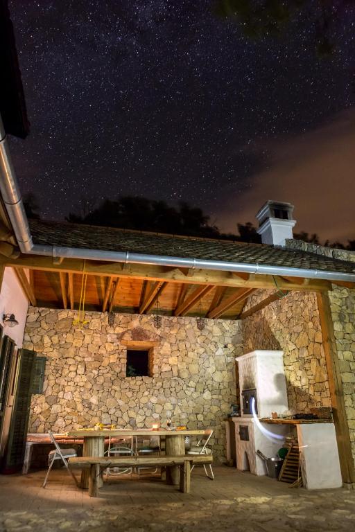 a stone building with a picnic table under a night sky at Henye holiday homes in Balatonhenye