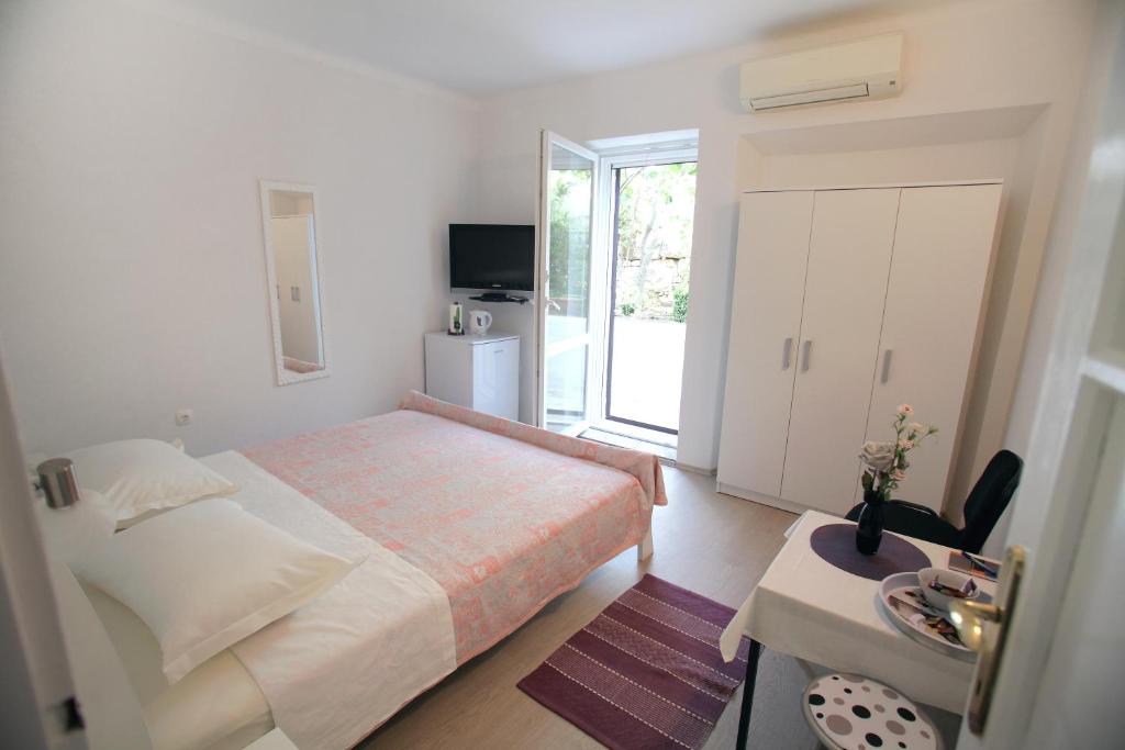 a small bedroom with a bed and a window at Rooms Feme in Trogir