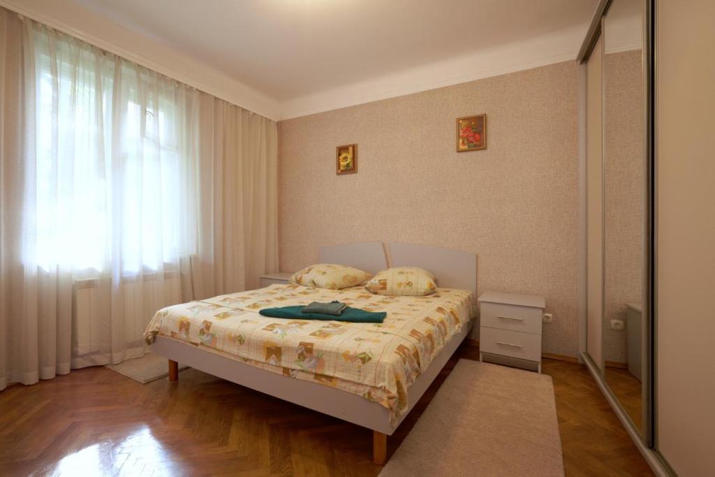 a bedroom with a bed with two pillows and a window at Apartment with courtyard in Lviv