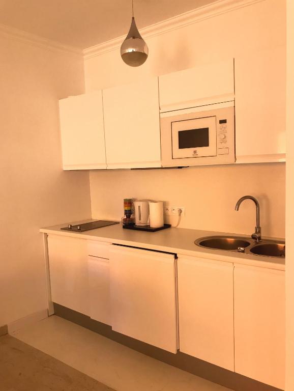 a kitchen with white cabinets and a microwave at Monaco Studio "907" in Monte Carlo