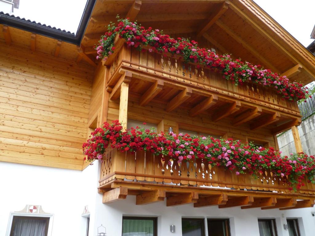 a balcony with flowers on a wooden building at Apartment Albert in Santa Cristina in Val Gardena