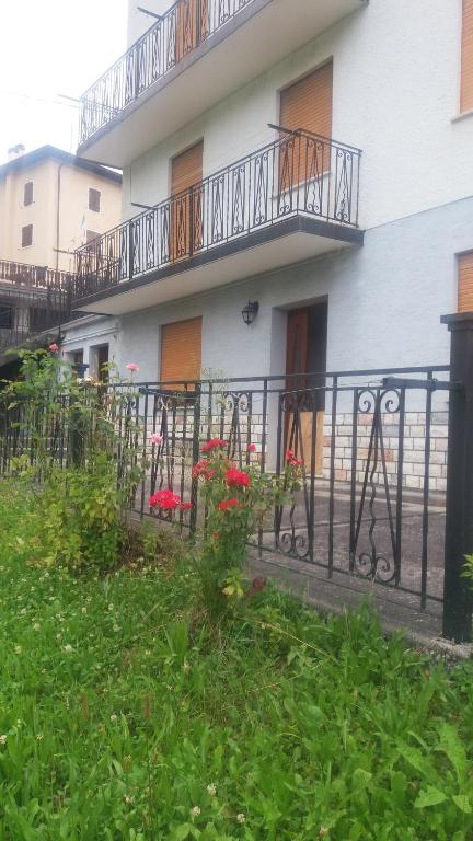 uma cerca em frente a um edifício branco com varandas em Casamanu em Enego