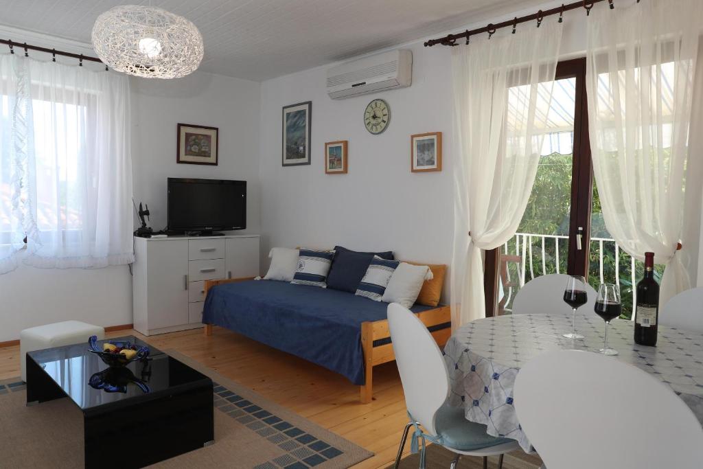 a bedroom with a bed and a table with chairs at Apartments Knezović in Rovinj