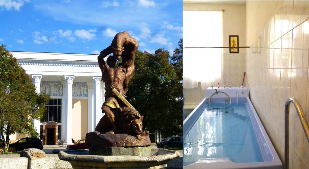 a statue in a fountain in front of a building at Country House Uliana in Tskaltubo