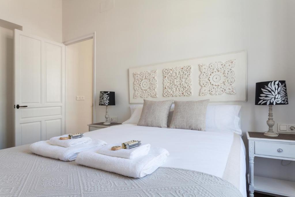 セビリアにあるStunning Boutique - Space Maison Apartmentsのベッドルーム1室(白いベッド1台、タオル付)