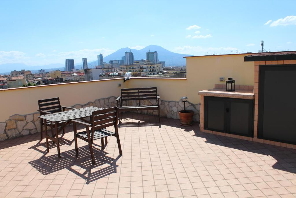 eine Terrasse mit einem Tisch und Stühlen auf dem Balkon in der Unterkunft L'occhio sul Vesuvio appartamento con terrazza privata e casa vacanza senza terrazza privata in Neapel