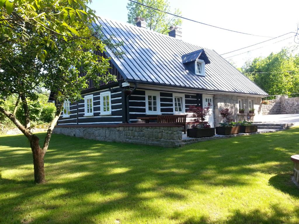 una casa en blanco y negro con un patio en Dom Nad Wodospadem pod Śnieżnymi Kotłami, en Jelenia Góra-Jagniątków