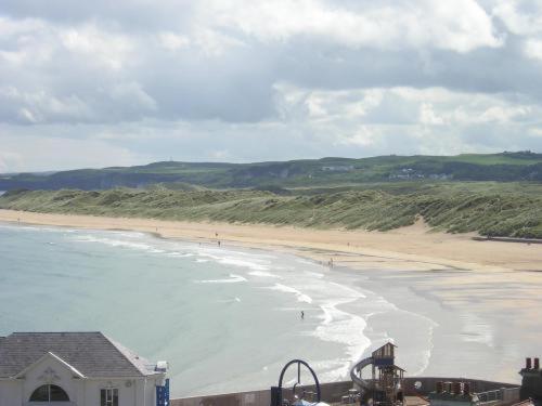 a view of a beach with people in the water at Albany Lodge in Portrush