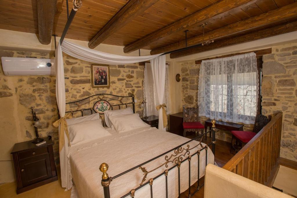 a bedroom with a bed and a table and a window at kritikies1 in Pitsidia