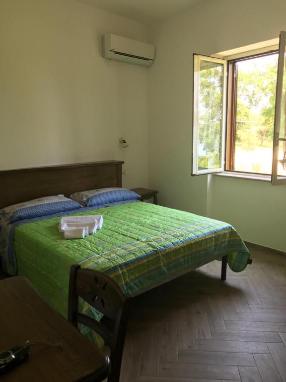 a bedroom with a green bed and a window at Luna D'Agerola in Agerola