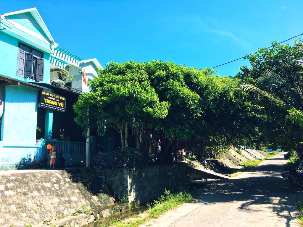 une rue avec des arbres devant un bâtiment dans l'établissement Trang Vu Homestay Cu Lao Cham, à Tân Hiệp