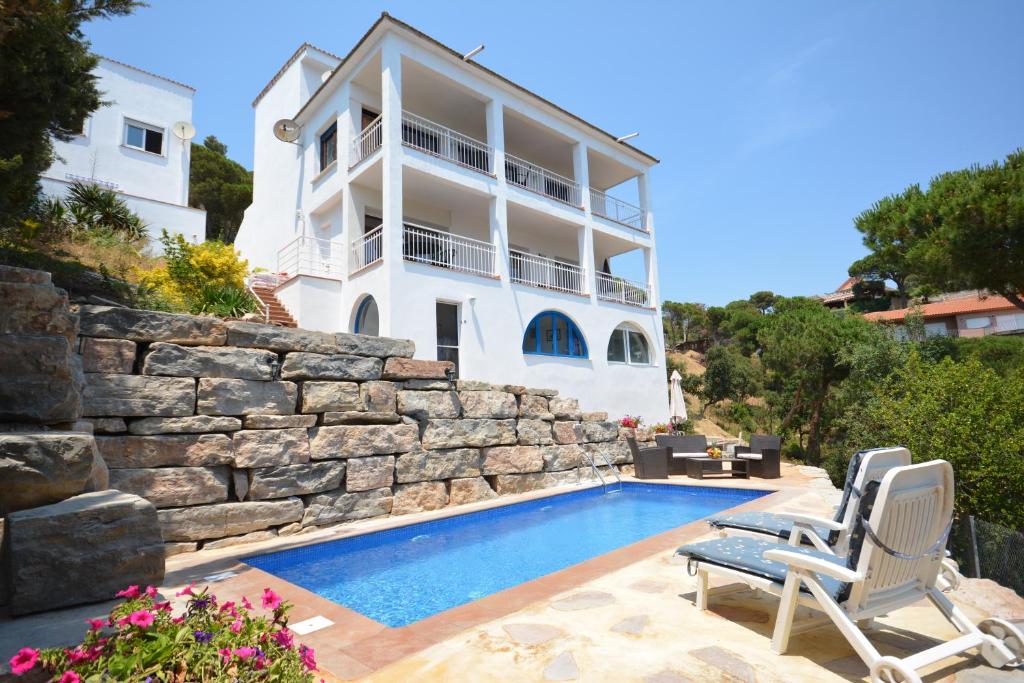 a villa with a swimming pool and a house at Lloret Apartments in Lloret de Mar