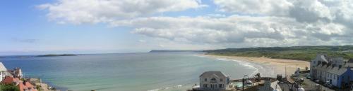 a view of a beach with buildings and the ocean at Albany Lodge in Portrush