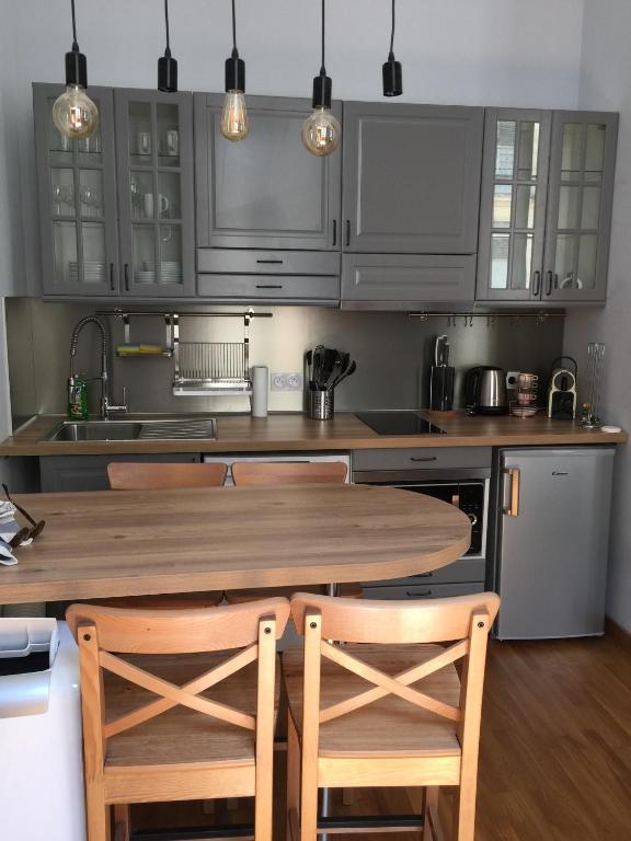 une cuisine avec une table en bois et deux chaises dans l'établissement Cœur de ville grand-rue Jean Moulin, à Montpellier