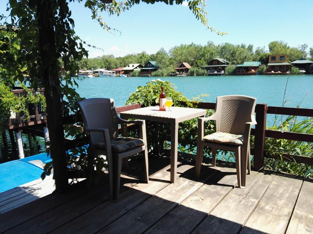 ウルツィニにあるAda Bojana Apartmaniのテーブルと椅子が備わるデッキから水辺の景色を望めます。