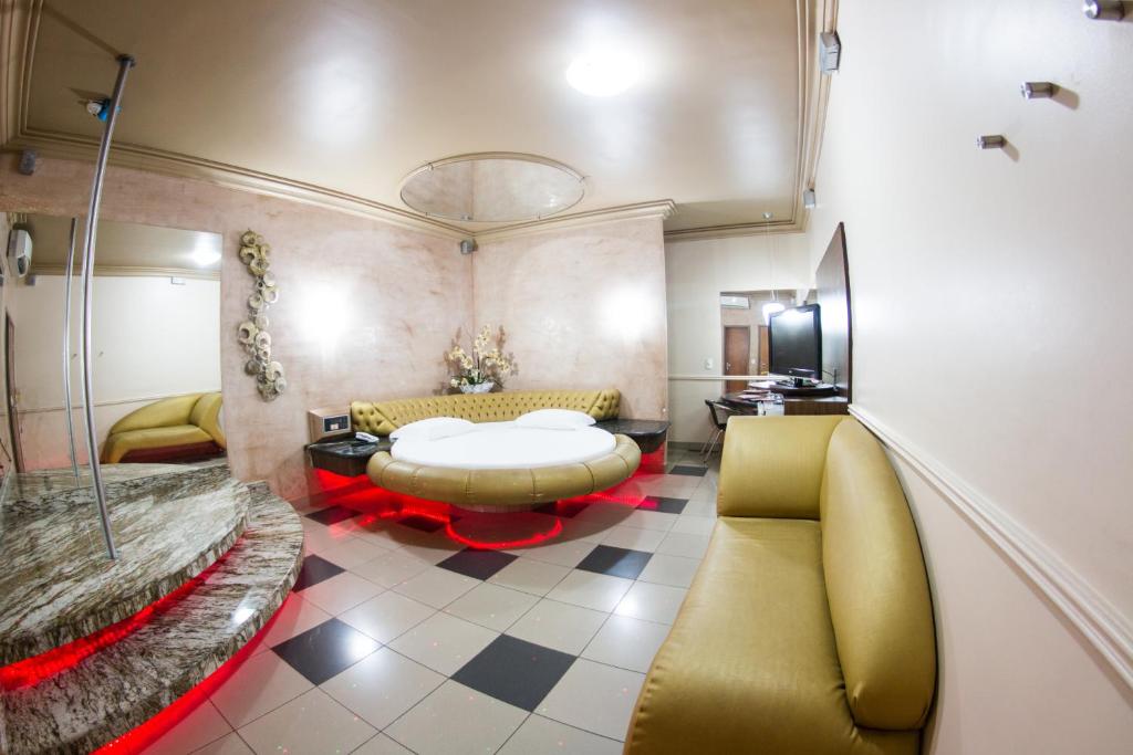 a living room with a yellow couch and a table at Shanadu Motel (Adults Only) in Fortaleza